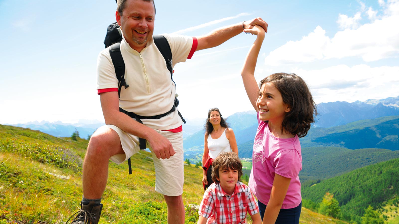 a family during a hike on a mountain near Hotel Alpenfrieden in summer